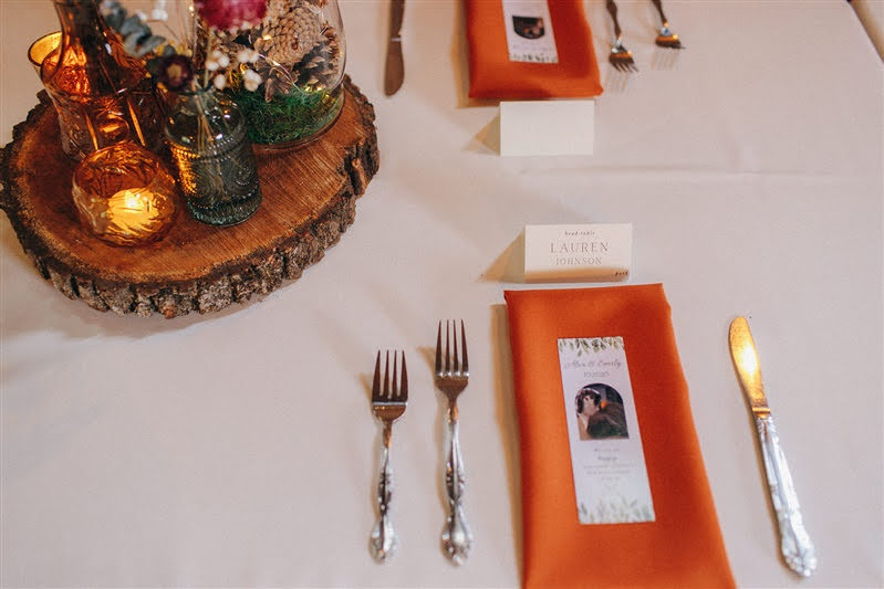 Bookmark wedding favors laid on top of an orange linen napkin for fall wedding at Cherry Basket Farm. 