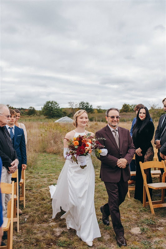 Bride and her father walking down the aisle for a fall wedding ceremony in Northern Michigan. 