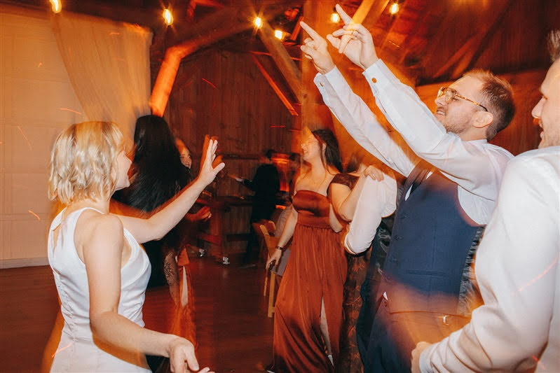 Couple and guests dancing on the dance floor during October wedding reception at Cherry Basket Farm. 